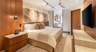 Image of a bed , nightstand and television in a Parlor Ocean-View Plus Suite.