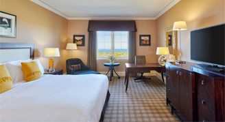 Image of the Deluxe Sea-View Room with one bed, seating area and adjacent window.