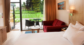 Image of a single bed leading to a patio and nearby garden area.