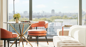 Image of a couch and table with chairs in a Deluxe Room.