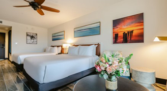 Image of two queen beds and circular table in a Deluxe Room.