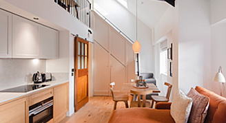 Feature one-bedroom suite living, dining, kitchen and stairwell to upper floor.