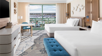 Harbor view room with two beds, mounted tv and a view of the park