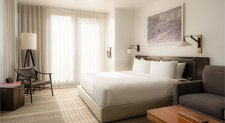 Interior view of the Corner Room with a king bed featuring an accessible tub.