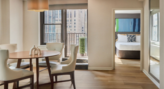 Image of a seating area leading to a terrace and bedroom in a One-Bedroom Apartment.