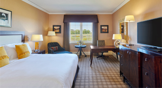 Image of the Fairmont Room with one bed, work desk and adjacent window.