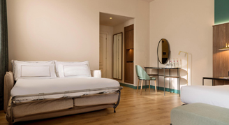 A two bed room with vanity in background.