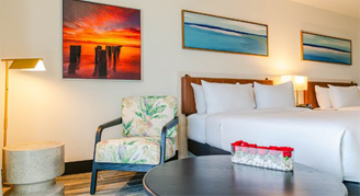 Image of two beds and a chair in a Deluxe Balcony Room.