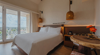 Image of a single bed leading to a balcony in an Island Room.