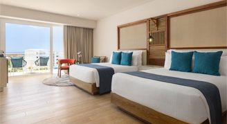Photo of hotel room with two queen-sized beds and a large balcony window.