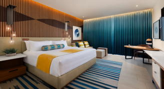 A view of a room with one bed, a seating area, and a television.