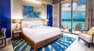 Image of single bed in a Deluxe Oceanfront Room leading to a balcony.