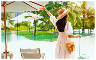 Woman with her luggage walking by a pool