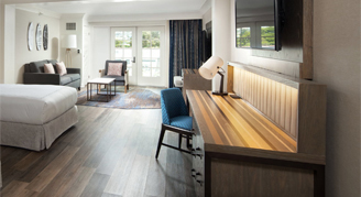 Image of a single bed and desk area in a Partial-Ocean-View Studio Suite with Balcony.