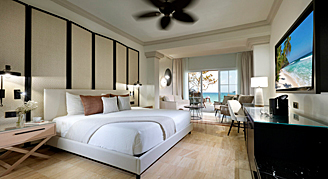 Junior Suite  featuring a king-size bed and a private balcony overlooking the ocean.