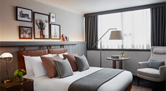 Room with double bed and arm chair and small table
