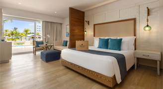 Photo of a hotel room with king bed and large balcony windows.