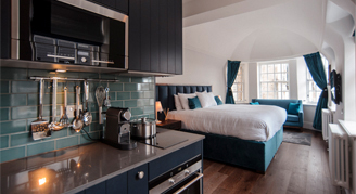Open-plan studio kitchen, bed and seating area.
