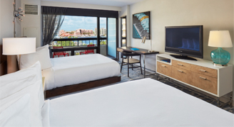 Image of two beds in a Water-View Room with Balcony.