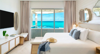 View of a King bed and window overlooking the water of the One-Bedroom Beachfront Penthouse Suite with Skypool.