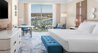 Harbor view room with a king bed, mounted tv and a view of the park