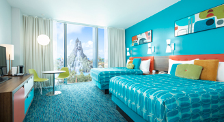 Image shows two beds with turquoise theme color ensemble and a background view of volcano view.