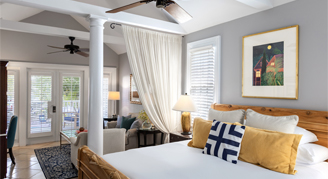 The Carriage house suite with a king bed and curtains separating the living room area 