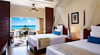 Two double beds with a balcony oceanfront view.