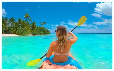 Woman kayaking in shallow water along the beach in Aitutaki