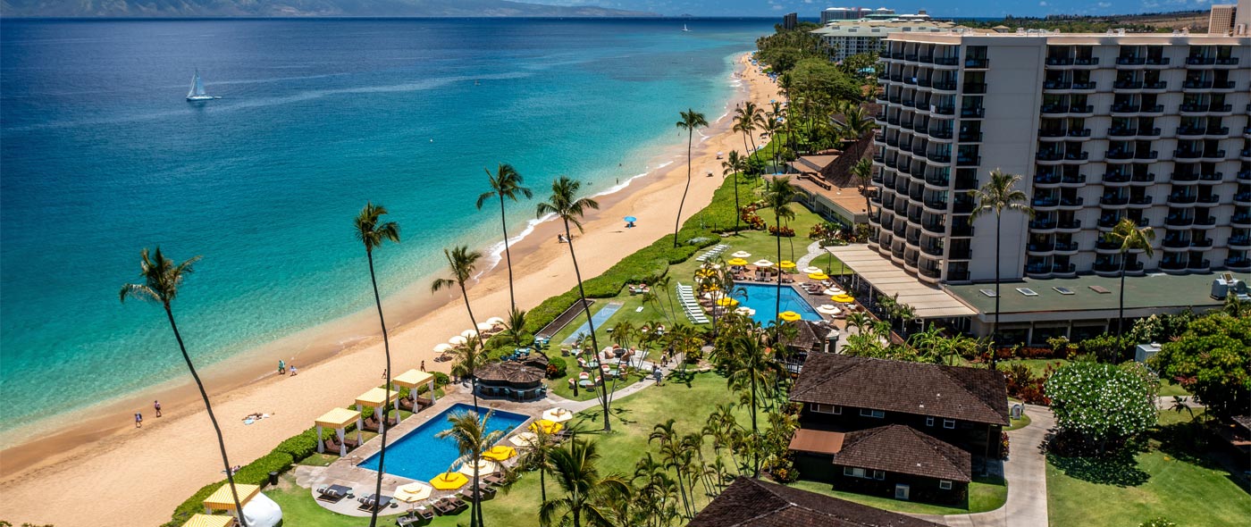 Aerial photo of hotel, pools and beach.