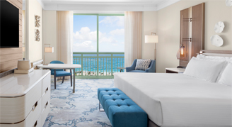 Water-view room with a king bed mounted tv and a view of the ocean