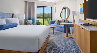 A view with king bed, furniture and balcony with a view.