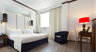 A king bed room with a desk and window.