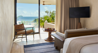 Image of a living area leading to a balcony in a Beachfront Signature Studio with Plunge Pool.