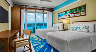 Image of two beds in a Deluxe Oceanfront Room leading to a balcony.