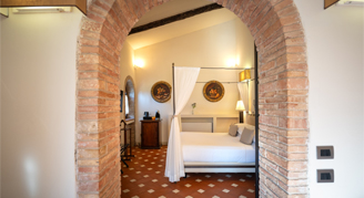 Image of a single bed through a brick doorway in a Prestige Room with Terrace.