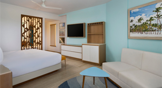 Photo of hotel room with king bed and sofa.