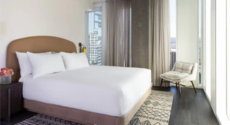 Photo of a hotel room with one bed and a small seating area.
