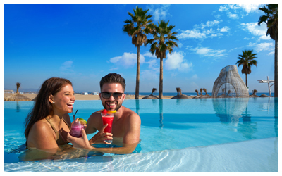 Couple drinking cocktails in a resort pool