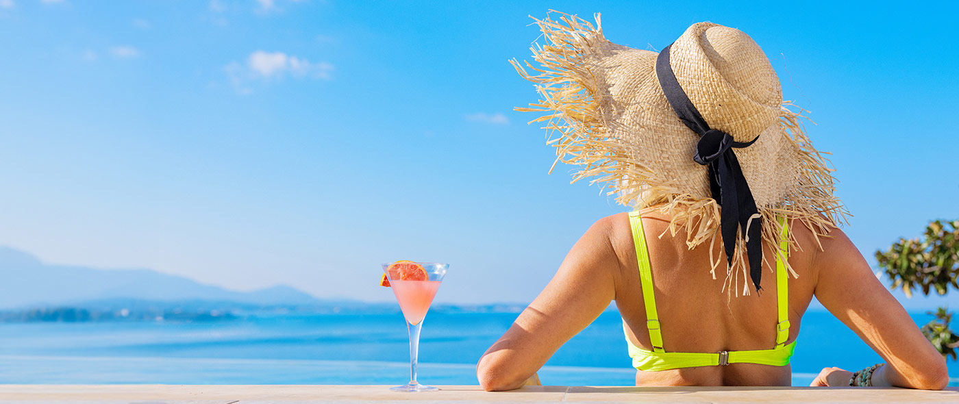 Woman with a drink overlooking the ocean